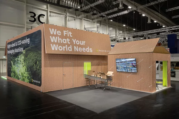 Messestand in Kartonoptik mit Lounge-Boxen und Sitzbereich, realisiert für Packsize.