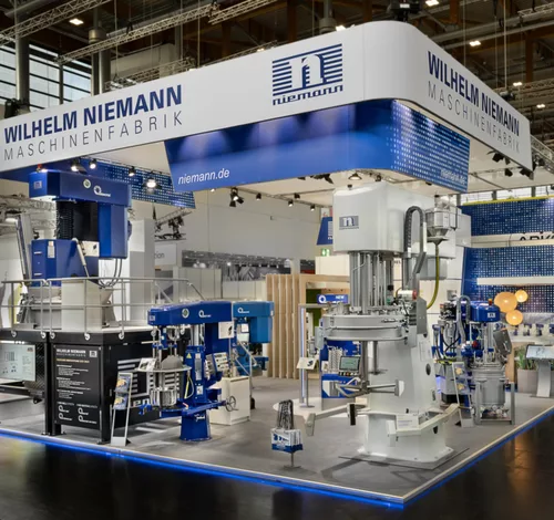 Messestand von Wilhelm Niemann mit großflächiger Maschinenpräsentation und markantem Deckenelement auf der Messe.