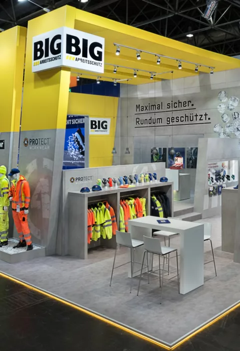  Nahaufnahme der Kleidungsausstellung und Schutzhelme am Stand.