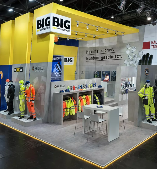  Nahaufnahme der Kleidungsausstellung und Schutzhelme am Stand.