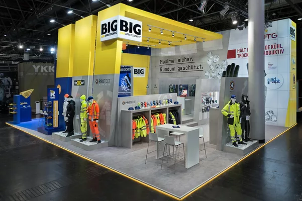  Nahaufnahme der Kleidungsausstellung und Schutzhelme am Stand.