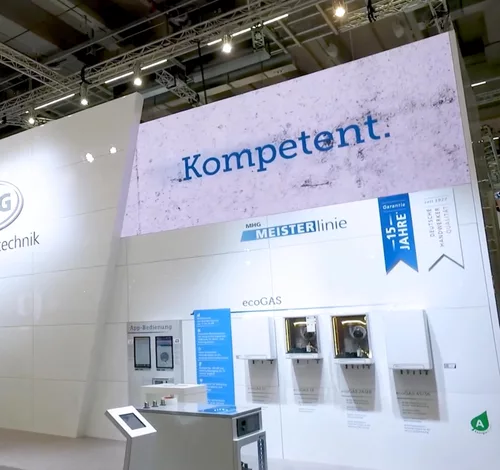 Messestand mit Bewegtbildern in einer Messehalle, auf einer Fläche steht "Kompetent" in blauer Schrift