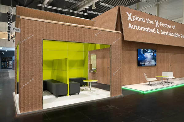Gesamtansicht des Messestandes in Kartonoptik mit Packsize-Branding auf der Messehalle.
