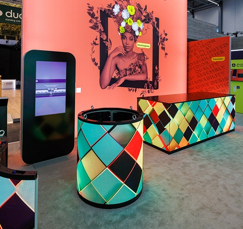 LED-beleuchtete Empfangstheke und Infodisplay vor dekorativer Grafik