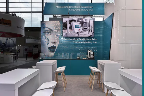 Detailansicht der Rückwand mit Videowall, Infografiken und modernem Barbereich mit Hockern.