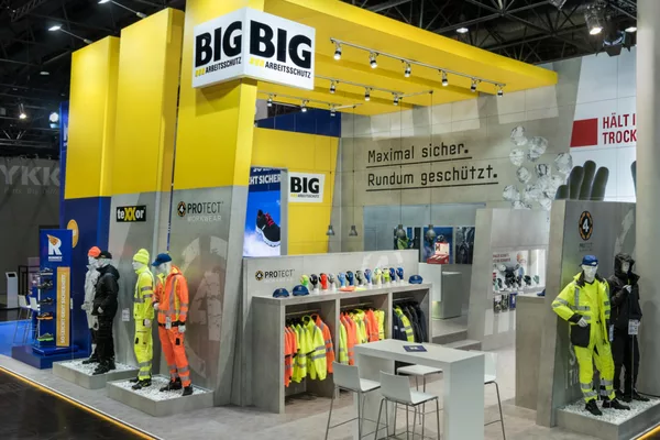  Messestand mit gelben Streben, Schutzausrüstung und Bekleidung.